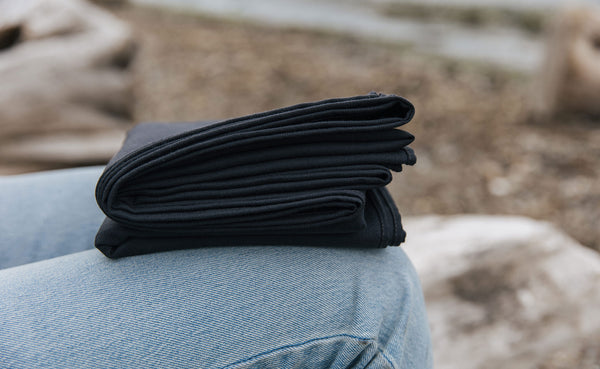 A Large Shepherd's Wool Utility Cloth in Matter Grey folded onto a person's lap.